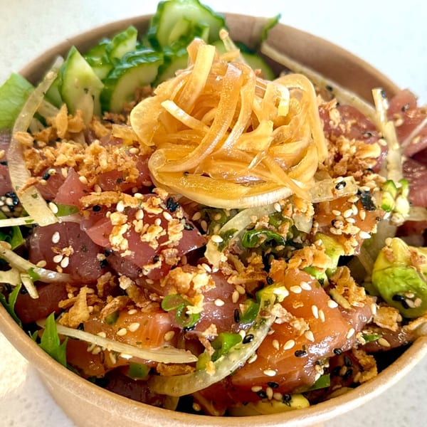 Close-up of a vibrant poke bowl from Sushi Friend, featuring fresh tuna, avocado, and crispy toppings.