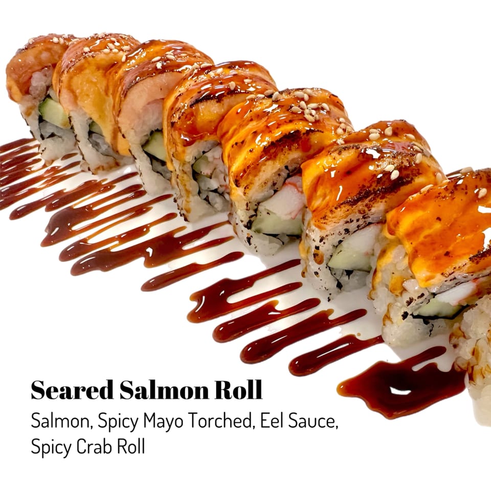 Seared Salmon Roll with spicy mayo, eel sauce, and sesame seeds on a white background.